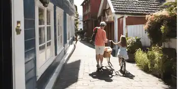 Two individuals strolling along a quaint street in a Tvedestrand old town.