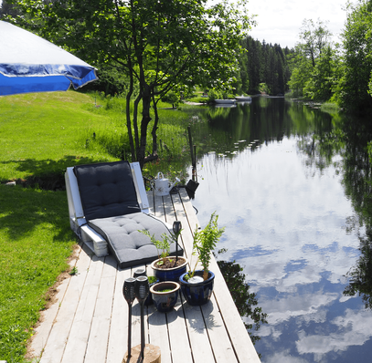 A sun lounger on a serene riverbank jetty, inviting relaxation amidst nature's beauty and the gentle flow of the tranquil river.