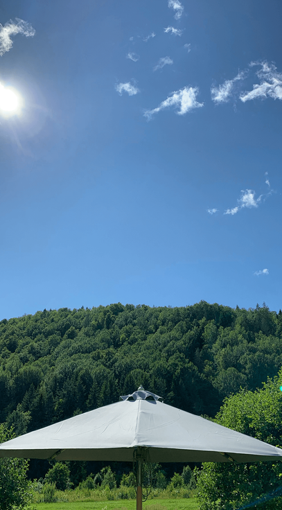 A charming seating area with a parasol, offering breathtaking mountain views for a tranquil outdoor retreat.