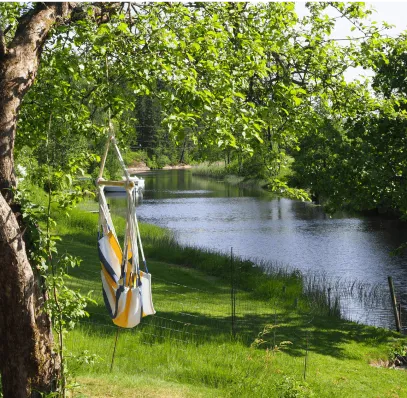 A hammock chair invites you to unwind, offering a serene view of the water's edge and a perfect escape into nature's embrace.